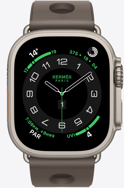 Apple Watch Hermès Ultra 3, titanium case, natural colour, Hermès Circulaire watch face, complications: weather, activity rings, Paris time, UV index, right side exterior, Digital Crown, microphone, raised side button, Scub’H Diving band, gris titane colour