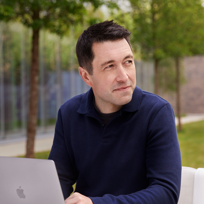 Close do Rob em um ambiente externo, com o laptop aberto.