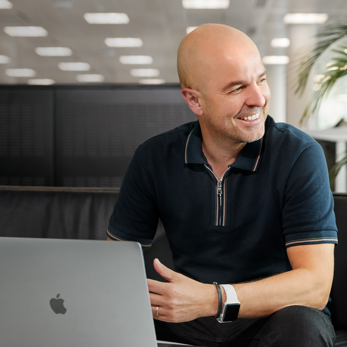 Close do Roberto sentado com um laptop.