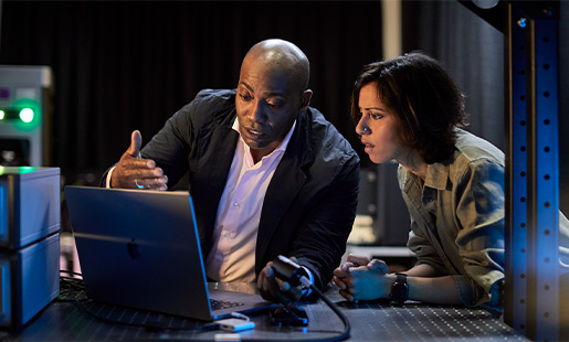 Mike og en kollega ser på en MacBook i et laboratorium.