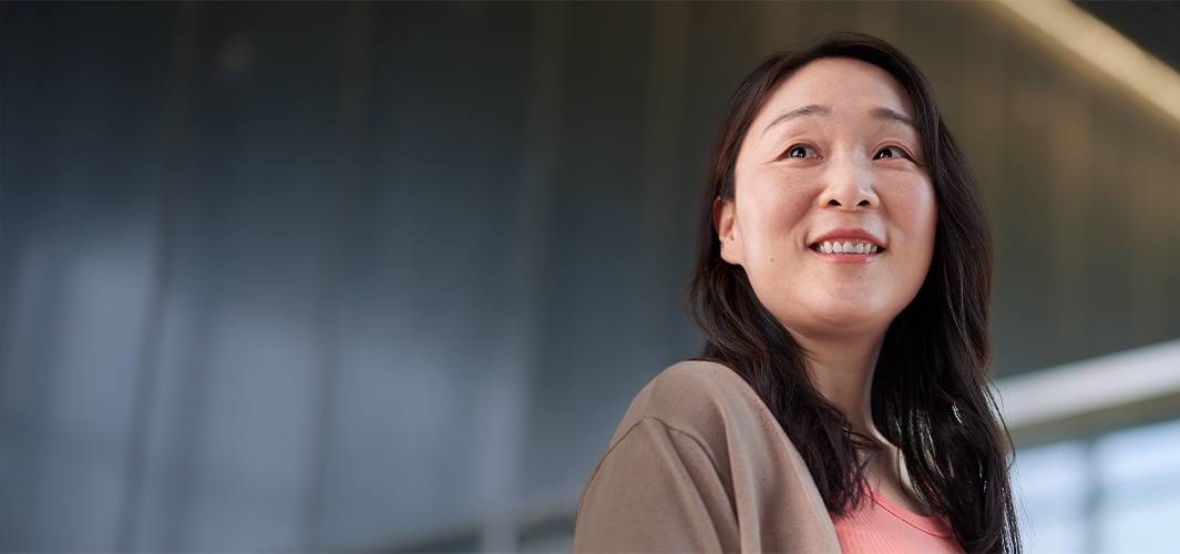 Chris ยืนยิ้มอยู่ในออฟฟิศ พลางหันมองไปทางซ้าย