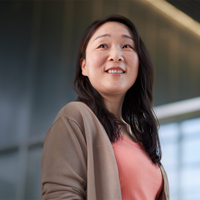 Chris ยืนยิ้มอยู่ในออฟฟิศและกำลังมองไปทางซ้าย