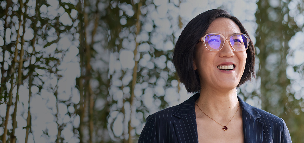 Ella ยิ้มและมองดูข้างบน ด้านหน้าของเธอเป็นสวนต้นไม้บนผนัง