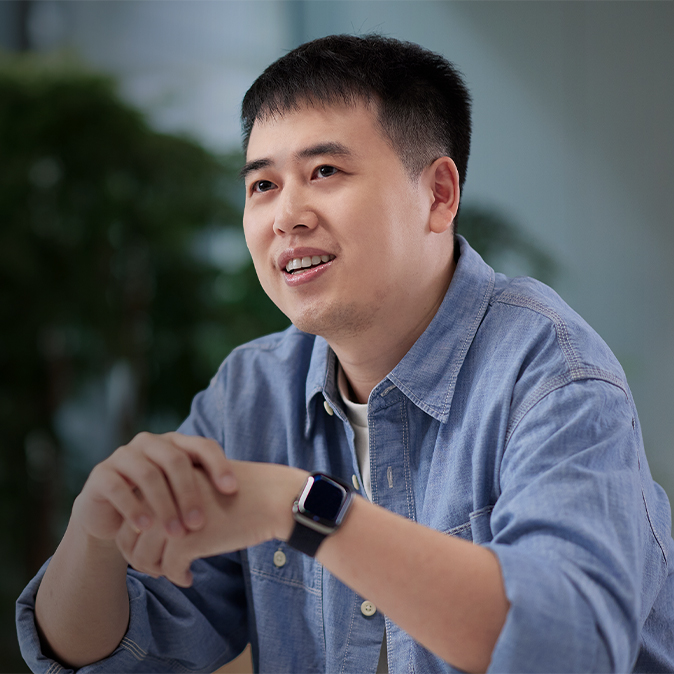  Ken นั่งอยู่ในอาคารที่เขียวสดชื่นไปด้วยต้นไม้