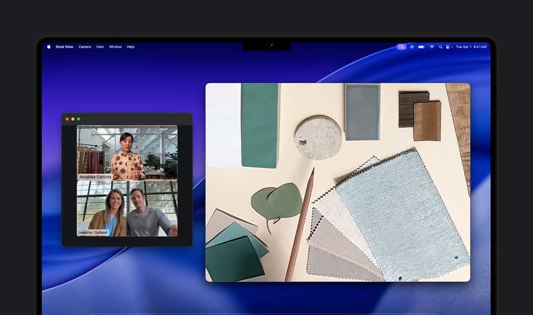 Ein Videoanruf auf dem MacBook Pro zeigt eine Frau, die die Schreibtischansicht nutzt, um zwei Personen im Anruf ihren Arbeitsplatz voller Stoffquadrate zu zeigen. Mit der Schreibtischansicht kann sie gleichzeitig ihren Arbeitsplatz und ihr Gesicht zeigen