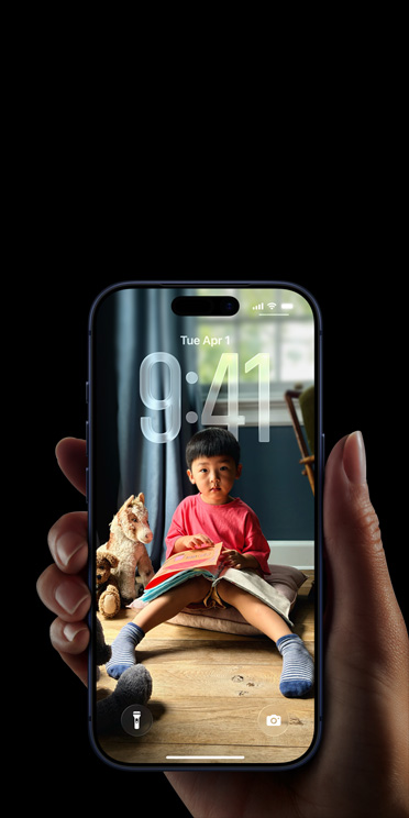 Tangan yang sedang memegang iPhone 17 Pro, pop-up Pesan muncul di Layar Terkunci yang dipersonalisasi