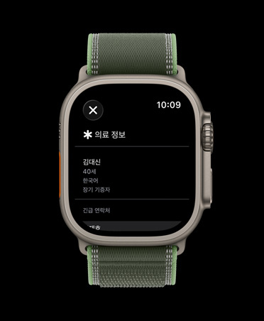 의료 정보 화면이 보이는 내추럴 색상 티타늄 케이스의 Apple Watch Ultra 3, 그리고 그린/네온 색상 트레일 루프