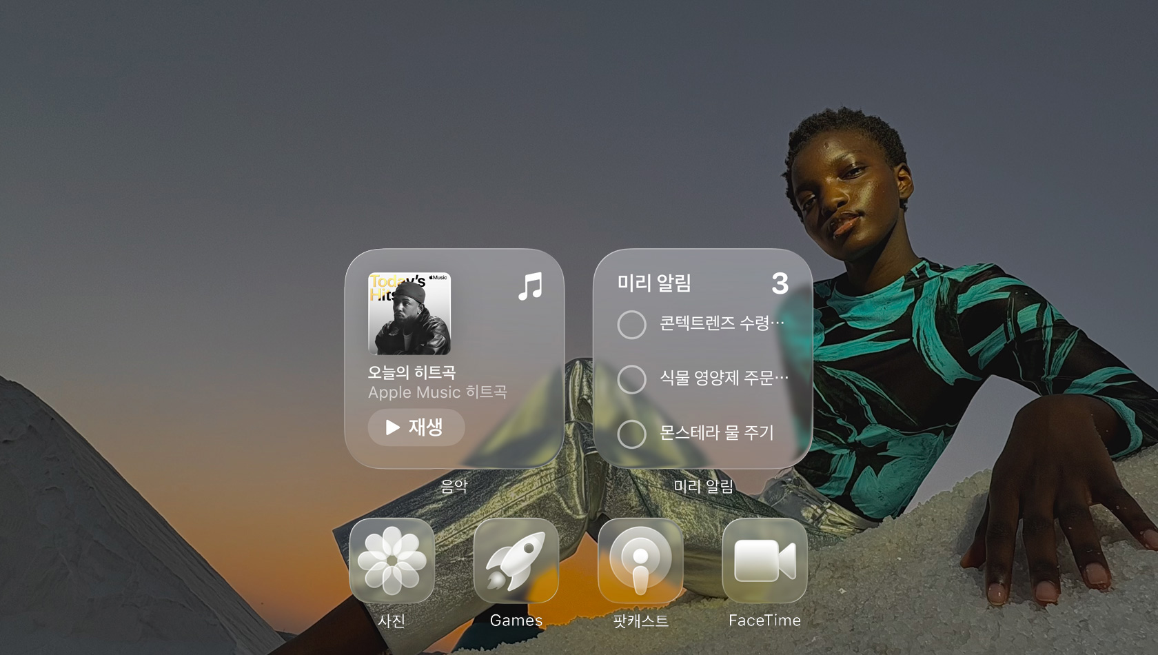 Apple Music, 미리 알림, 사진, 게임, 팟캐스트, FaceTime 등의 투명한 앱 아이콘들이 배경화면을 굴절시키는 Liquid Glass 화면