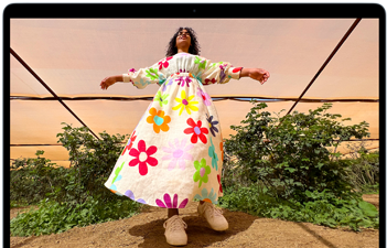 MacBook Air 螢幕上顯示相片，相中人穿著色彩繽紛的服裝，展示 Liquid Retina 顯示器的色域和解像度