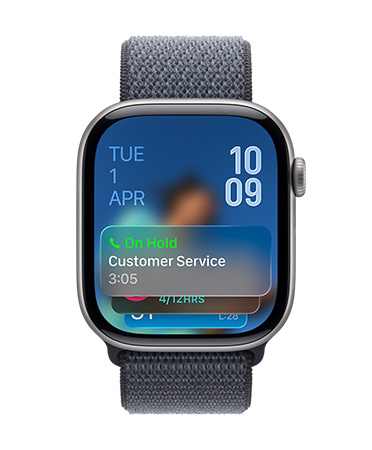 Apple Watch in Jet Black with Sage Strap, Face shows Hold assist notification at bottom, date on top left, time numerals stacked at top right