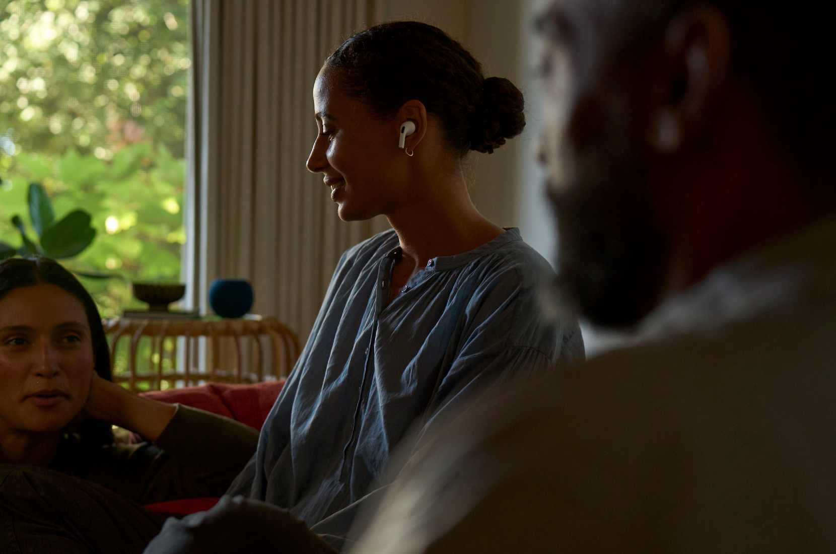 Pohled z boku na ženu s AirPodem Pro 2 v levém uchu při používání funkce na podporu zdraví sluchu