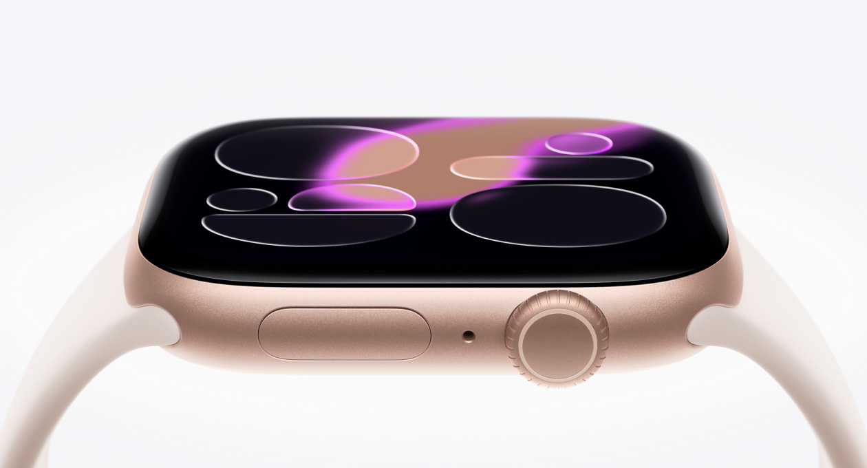Apple Watch Series 11, caja de aluminio, color oro rosa, lateral derecho, la pantalla de vidrio Ion-X reforzado flota encima del reloj, Digital Crown, micrófono, botón lateral, sensor convexo en la parte inferior, correa deportiva, color rosa rubor