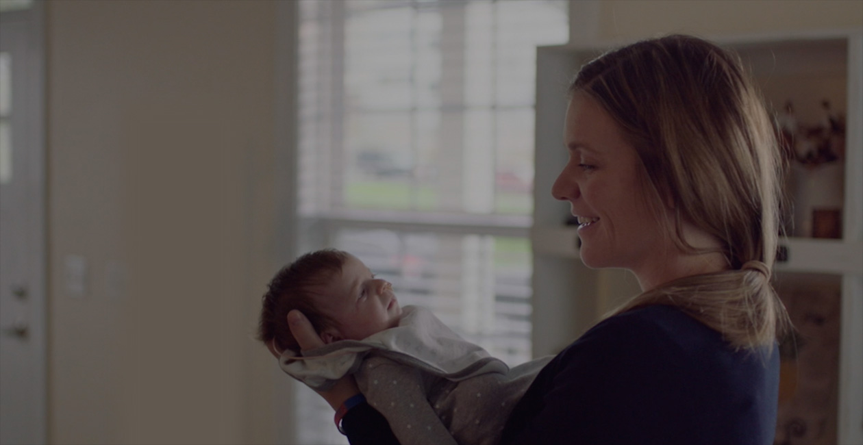 Una madre che sorride al suo bimbo appena nato.