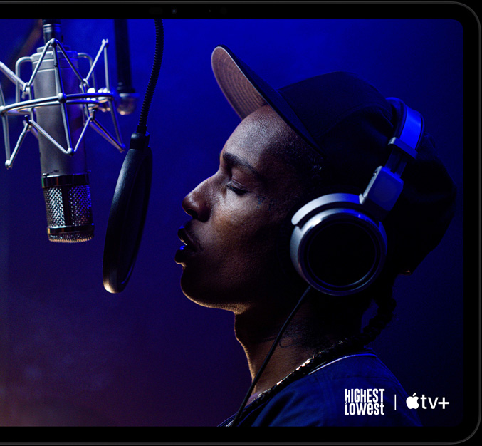 iPad Pro, orientation paysage, face avant, noir sidéral, angles arrondis, cadre d’écran noir, écran affichant Apple TV+ en train de diffuser une scène du film original Apple TV+ Highest 2 Lowest avec ASAP Rocky dans le rôle de Yung Felon en train de rapper dans un micro