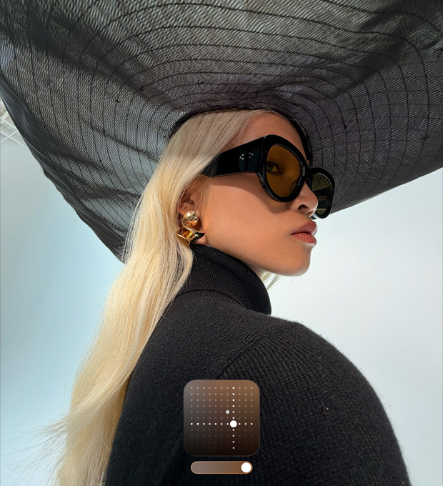 Ένα πορτρέτο μιας γυναίκας που φοράει ένα μαύρο καπέλο με φαρδύ γείσο δείχνει το Φωτεινό Φωτογραφικό Στυλ, το οποίο φωτίζει τις φωτογραφίες που τραβήχτηκαν σε συνθήκες χαμηλού φωτισμού ή σε Νυχτερινή λειτουργία