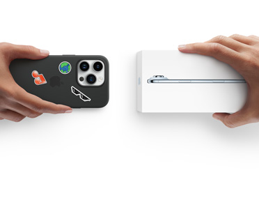 En hånd holder en iPhone 13 med silikone-etui med klistermærker på bagsiden, ved siden af holder en anden hånd en æske med en ny iPhone 17