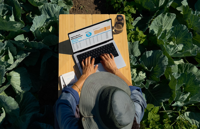 Човек използва MacBook Pro с опция за дисплей с нанотекстура навън, демонстрирайки намалени отблясъци